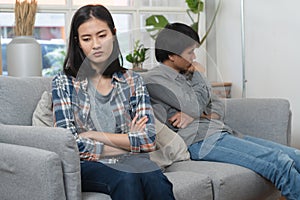 Family crisis. Asian wife crying on the sofa after husband cheating on her