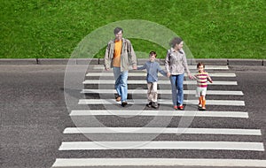 Family and crossing road, green fence and grass