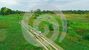 Family cycling on bikes aerial view from above, happy active mother with children have fun outdoors in spring park, family sport