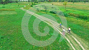 Family cycling on bikes aerial view from above, happy active mother with children have fun outdoors in spring park, family sport