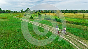 Family cycling on bikes outdoors aerial view from above, active mother with children have fun, family sport and fitness