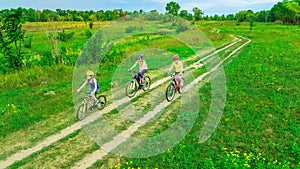 Family cycling on bikes outdoors aerial view from above, active mother with children have fun, family sport and fitness