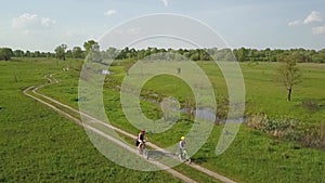 Family cycling on bikes outdoors aerial view from above, happy active mother with child have fun, family sport