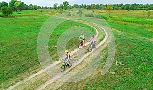 Family cycling on bikes outdoors aerial view from above, happy active mother with children have fun, family sport