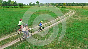 Family cycling on bikes outdoors aerial view from above, happy active mother with children have fun, family sport