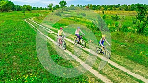 Family cycling on bikes outdoors aerial view from above, happy active mother with children have fun, family sport