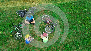 Family cycling on bikes outdoors aerial view from above, happy active parents with child have fun and relax, family sport