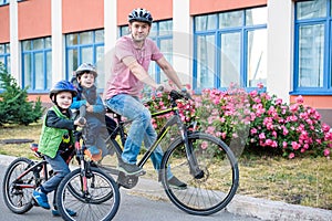 Family cycling, father with happy kid riding bike outdoors