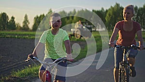 Family cycling in a field at sunset.