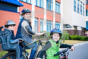 Family cycling, mother with happy kid riding bike outdoors