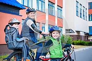 Family cycling, mother with happy kid riding bike outdoors