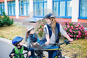 Family cycling, mother with happy kid riding bike outdoors