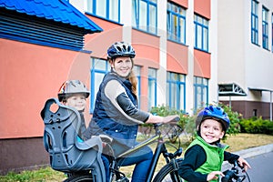 Family cycling, mother with happy kid riding bike outdoors