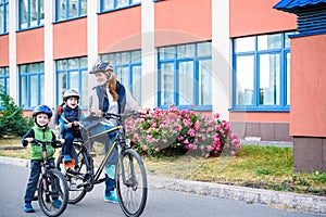 Family cycling, mother with happy kid riding bike outdoors