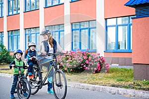 Family cycling, mother with happy kid riding bike outdoors