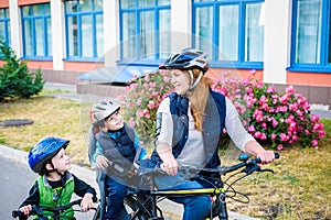 Family cycling, mother with happy kid riding bike outdoors