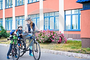 Family cycling, mother with happy kid riding bike outdoors