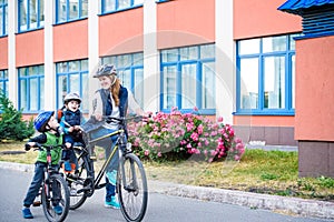 Family cycling, mother with happy kid riding bike outdoors