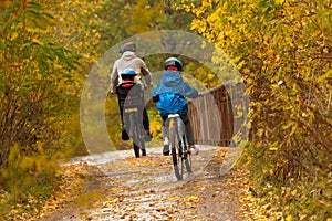 Family cycling outdoors, autumn park