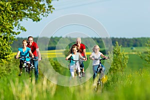 Family cycling outdoors in summer