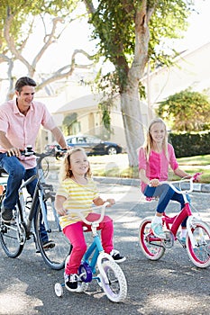 Family Cycling On Suburban Street