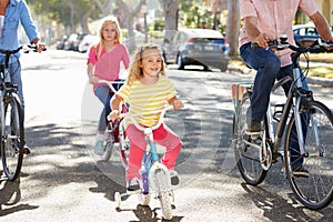 Family Cycling On Suburban Street