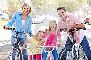 Family Cycling On Suburban Street