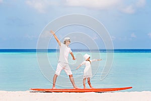 Family of dad and kid on surfboard during summer vacation