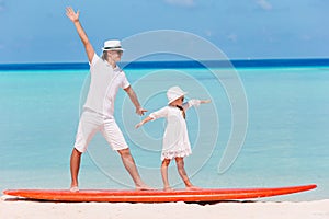 Family of dad and kid on surfboard during summer vacation