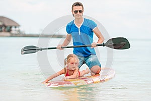 Family of dad and kids on surfboard during summer vacation