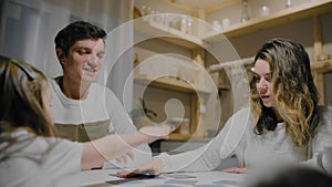 Family dad mom and daughter play board card games at the table