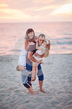 Family: dad, mom, daughter and son. Children with mom jumped to dad on the back photo