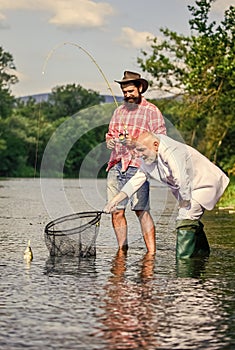 Family day. retired dad and mature bearded son. Two male friends fishing together. fly fish hobby of businessman