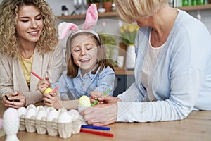 Happy family decorates easter eggs at home photo