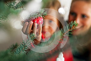 Family decorating Christmas tree photo