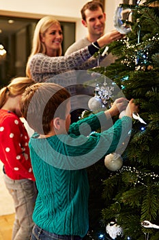 Family Decorating Christmas Tree At Home Together photo