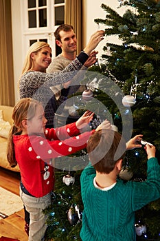 Family Decorating Christmas Tree At Home Together photo