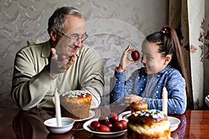 Family Decorating Easter Eggs On Table, grandfather and granddaughter.