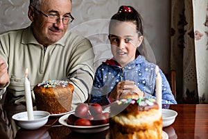 Family Decorating Easter Eggs On Table, grandfather and granddaughter.