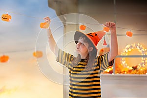 Family decorating home. Halloween pumpkin lights