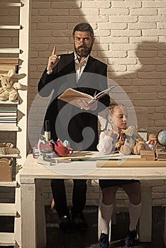 Family by desk with school supplies. Girl and father