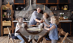 Family dinner: Mom distributes sweet tea cakes for dessert to three children.