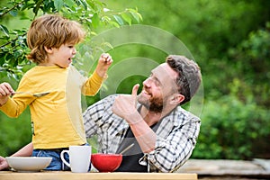 Family dinner time. father and son eating outdoor. happy fathers day. Little boy with dad eat cereal. summer picnic