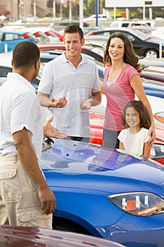 Family discussing new car with salesman