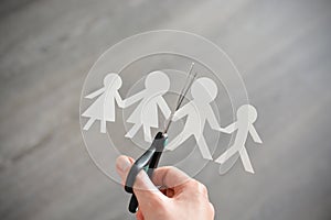 Family divorce concept with human paper shapes and scissors