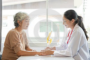 Family doctor examining smiling asian old woman using stethoscope at hospital An old woman talks