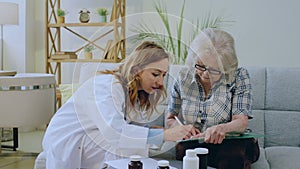 Family doctor wearing the white coat came to the patient at home she explain the treatment that the patient old woman