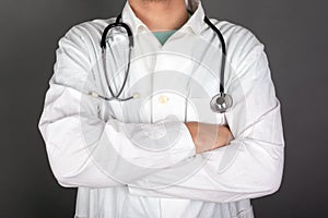 Family doctor in a white coat with a stethoscope on a gray background, pediatrician, close-up