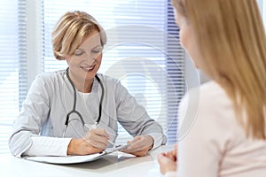 Family doctor write notes in patient medical records