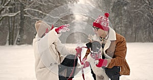 Family with a dog in funny accessorie in winter park